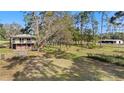 Charming two-story home with a large yard, trees, outbuildings, and a fenced area in a serene country setting at 18838 Huckavalle Rd, Odessa, FL 33556