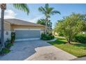 Charming home showcases a decorative garage door, complemented by colorful landscaping and a long driveway at 2007 Acadia Greens Dr # 0, Sun City Center, FL 33573