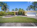 Inviting single-story home features lush landscaping, well-manicured lawn, and an attached two-car garage at 2142 Ibis, Clearwater, FL 33764