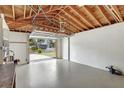A spacious garage with an open door, exposed ceiling and a sealed concrete floor at 3065 Merrill Ave, Clearwater, FL 33759