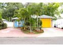 Charming blue home featuring well-manicured landscaping and a bright yellow garage door at 3306 E Chelsea St, Tampa, FL 33610