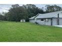 Spacious backyard with lush green lawn and shed, perfect for outdoor activities at 35209 Dolphin Lake Dr, Zephyrhills, FL 33541