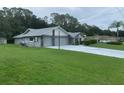 Beautiful view of home featuring landscaped lawn and a long driveway leading to a 2 car garage at 35209 Dolphin Lake Dr, Zephyrhills, FL 33541