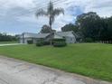 Great front view of home with a well-manicured front yard and a two-car garage at 35209 Dolphin Lake Dr, Zephyrhills, FL 33541