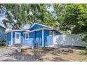 Backyard view of a charming blue house with a small deck and fenced yard at 3706 N Ola Ave, Tampa, FL 33603