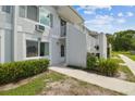 Close view of a two-story condo unit showcasing its clean exterior, balcony and lush landscaping at 4141 Dolphin Dr # 4141, Tampa, FL 33617