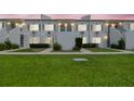 A charming two-story condo building in a residential area shown at dusk with manicured lawn and shrubbery at 4141 Dolphin Dr # 4141, Tampa, FL 33617