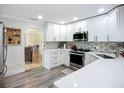 Modern kitchen with white cabinets, stainless steel appliances, and attractive backsplash tiles at 4231 8Th N St, St Petersburg, FL 33703