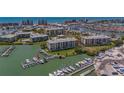 Aerial view of condo building with boat docks, lush green surroundings, and proximity to the ocean at 425 150Th Ave # 2301, Madeira Beach, FL 33708