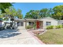 Inviting single-story home with a concrete driveway and a well-manicured lawn surrounded by mature trees at 4425 W Bay Villa Ave, Tampa, FL 33611