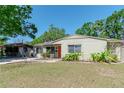 Inviting single-story home featuring a well-maintained lawn and a vibrant, inviting front door at 4425 W Bay Villa Ave, Tampa, FL 33611