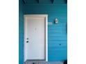 Charming front door with bright blue siding and white trim at 455 Alt 19 S # 235, Palm Harbor, FL 34683