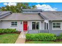 Charming single-story home featuring a red door with wreath and a well-maintained front lawn at 50 Balsam Dr, Oldsmar, FL 34677