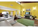 Inviting living room featuring bright yellow walls, hardwood floors, and a green area rug at 50 Balsam Dr, Oldsmar, FL 34677