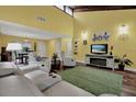 Open living area features wood floors, vaulted ceilings, modern furnishings, and a green area rug at 50 Balsam Dr, Oldsmar, FL 34677