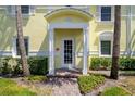 Charming condo front door entrance with palm trees, brick walkway, and lush greenery at 5174 Beach Se Dr # B, St Petersburg, FL 33705