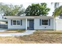 Charming single-story home with gray siding, front yard landscaping, and a neutral-colored front door at 551 84Th N Ave, St Petersburg, FL 33702