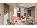 Relaxing front porch features two white rocking chairs with red cushions for enjoying the outdoors at 5735 Mezzana Run, Palmetto, FL 34221