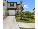 Charming two-story townhouse with a well-maintained front lawn and a sidewalk at 7018 Ripple Pond Loop, Zephyrhills, FL 33541