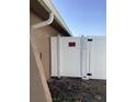 View of a white side gate with a 'Posted No Trespassing' sign, indicating property boundaries and security at 7321 Isle Dr, Port Richey, FL 34668