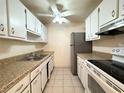Functional kitchen features white cabinets, laminate countertops, tile floors, and essential appliances at 8320 112Th St # 107, Seminole, FL 33772