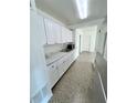 Bright kitchen featuring stainless steel appliances, white cabinetry, and marble countertops at 5604 Larimer Dr, Tampa, FL 33615