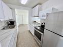 Bright kitchen featuring stainless steel appliances, white cabinetry, and marble countertops at 5604 Larimer Dr, Tampa, FL 33615