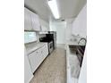 Bright kitchen featuring stainless steel appliances, white cabinetry, and marble countertops at 5604 Larimer Dr, Tampa, FL 33615