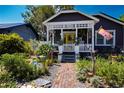 Inviting curb appeal with a gray exterior, covered porch, and a colorful front yard garden display at 1036 23Rd N Ave, St Petersburg, FL 33704
