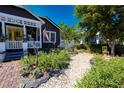 Landscaped front yard with a stone path leading to the home, surrounded by lush greenery and garden decor at 1036 23Rd N Ave, St Petersburg, FL 33704