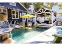Backyard pool featuring a stone waterfall, surrounded by seating areas and lush landscaping for relaxation at 1036 23Rd N Ave, St Petersburg, FL 33704