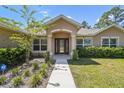 Beautiful home entrance featuring a well-manicured lawn and tasteful landscaping at 11165 Little Gull Rd, Weeki Wachee, FL 34614