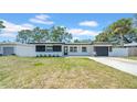 Charming single-story home featuring fresh white paint, black accents and an attached garage at 1416 Murray Ave, Clearwater, FL 33755