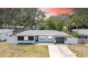 Charming single-story home featuring fresh white paint, black accents and an attached garage at 1416 Murray Ave, Clearwater, FL 33755