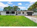 Charming single-story home with well-manicured lawn, updated exterior, and attached garage at 1416 Murray Ave, Clearwater, FL 33755