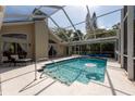Sparkling screened-in pool featuring a clear blue water, and neutral-colored deck, great for relaxation at 1551 Mcauliffe Ln, Palm Harbor, FL 34683