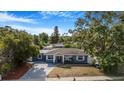 Quaint single-Gathering home featuring mature trees, a well-kept lawn, and a welcoming facade at 1625 Fulton Ave, Clearwater, FL 33755