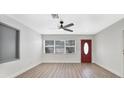 Bright, open living room with modern ceiling fan, wood flooring, and natural light from large windows at 1625 Fulton Ave, Clearwater, FL 33755