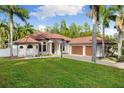 Home's exterior features include a tile roof, arched entryway, two-car garage, and paver driveway at 17347 Linda Vista Cir, Lutz, FL 33548