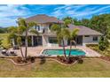 Aerial view of a private backyard with a sparkling pool, brick patio, and lush landscaping at 18202 Bledsoe Loop, Lithia, FL 33547