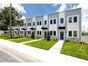 Street view of townhomes featuring a landscaped lawn and matching trees and shrubbery at 3402 E 28Th Ave # 6, Tampa, FL 33605