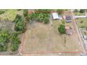 Expansive property featuring a residence, outbuildings, wooded areas, and large open field, ideal for various uses at 3515 Bell Farms Dr, Plant City, FL 33566