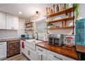 Well-organized kitchen featuring open shelving, farmhouse sink, and butcher block countertops at 3515 Bell Farms Dr, Plant City, FL 33566