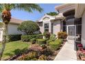 Front exterior view of the home showcasing manicured shrubs, a walkway, and a well-kept lawn at 3964 Silk Oak Ln, Palm Harbor, FL 34685