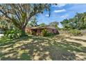 Landscaped front yard with mature tree shading this charming brick home at 402 Merlin Ct, Brandon, FL 33510