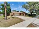 Brick home featuring an arched doorway, two-car garage, and a spacious driveway at 402 Merlin Ct, Brandon, FL 33510