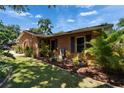 Landscaped front yard with mulch beds and a variety of plants framing this brick home at 402 Merlin Ct, Brandon, FL 33510