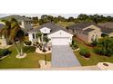 Aerial view of a home showcasing a well-manicured lawn, complemented by decorative landscaping and an extended driveway at 443 Noble Faire Dr, Sun City Center, FL 33573