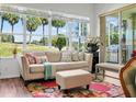 Bright living room with a large window offering serene golf course views, comfortable seating, and stylish decor at 443 Noble Faire Dr, Sun City Center, FL 33573