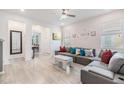 Bright living room featuring a gray sectional, white walls, modern décor and vinyl flooring at 5743 Skytop Dr, Lithia, FL 33547